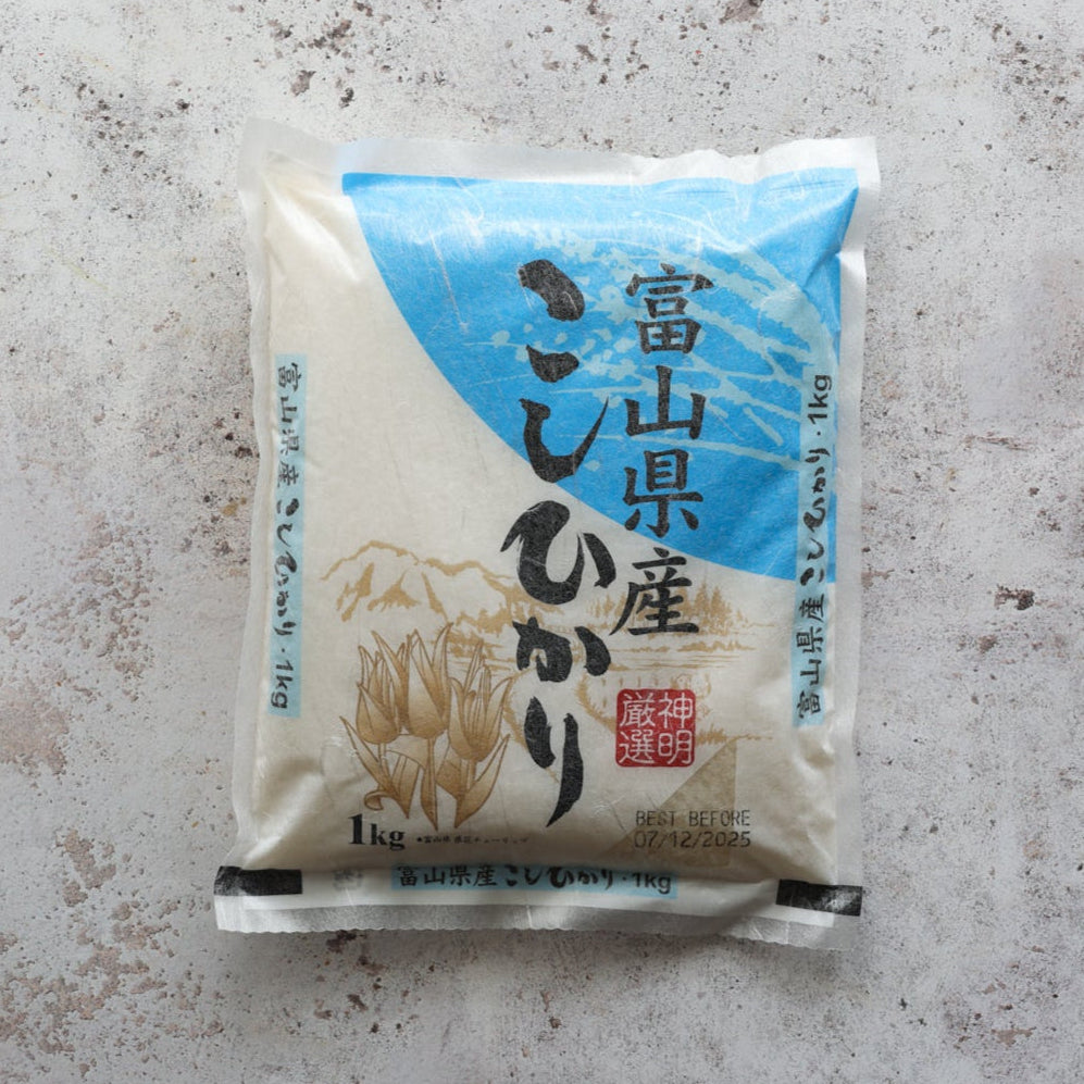 Koshihikari Toyama Rice 1kg pack with Japanese text and mountain illustration, premium short-grain rice ideal for sushi and Japanese dishes.