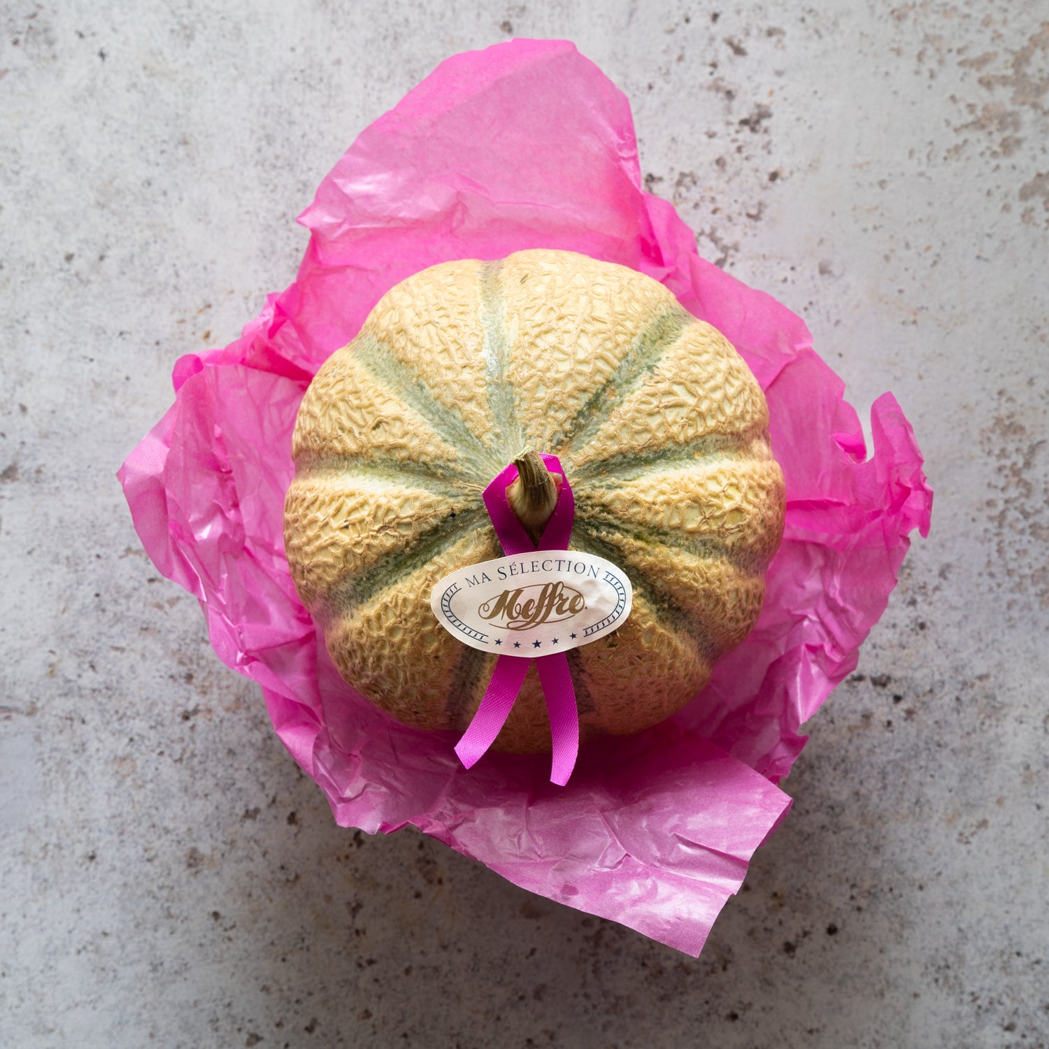 Charentais Melon | Premium French Cantaloupe | FINE & WILD wrapped in pink tissue with label, showcasing sweet orange flesh and floral aroma.
