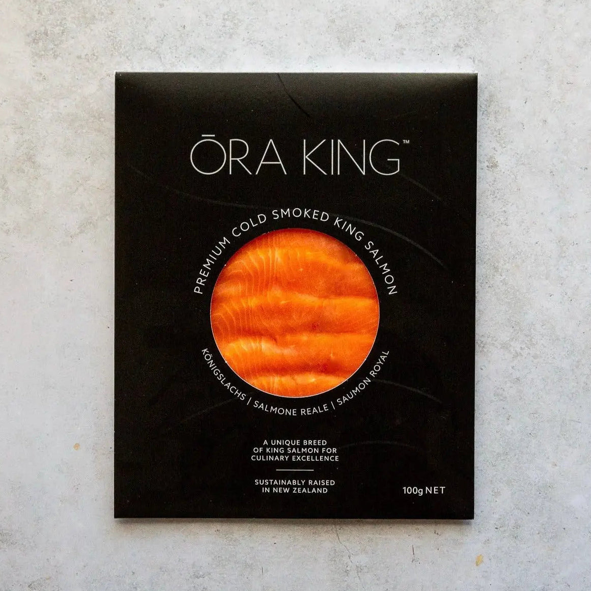 SMOKED ŌRA KING SALMON | FINE & WILD UK premium cold smoked salmon in black packaging, showcasing vibrant orange D-cut slices from New Zealand.