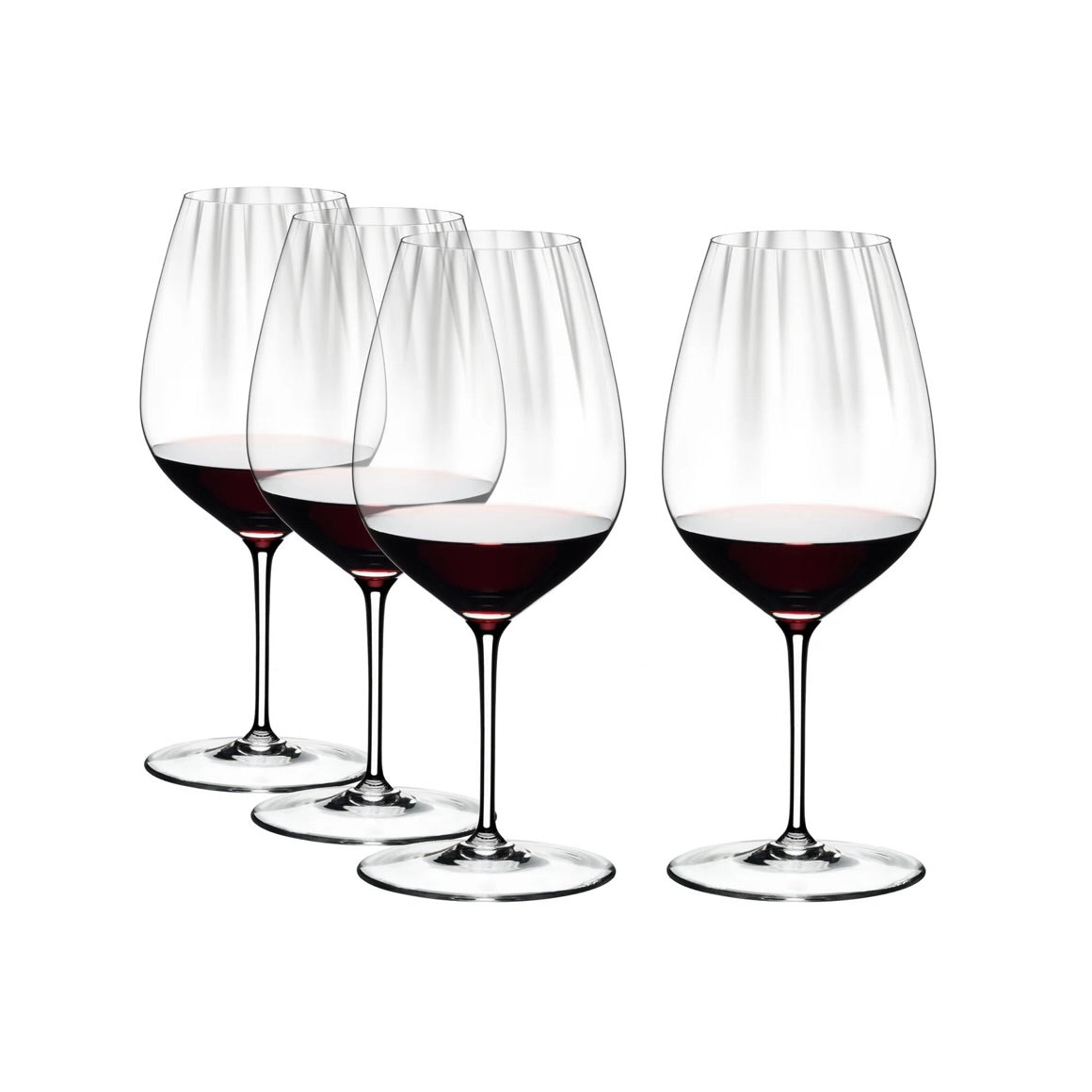 Set of four RIEDEL Performance Cabernet / Merlot wine glasses with tall bowls, clear glass, and thin stems, partially filled with red wine