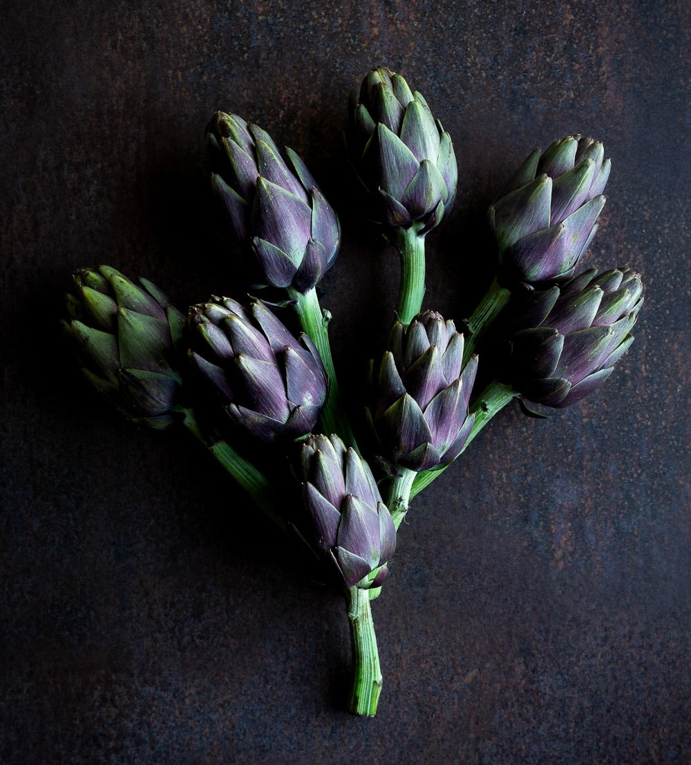 Bunch of violet artichokes on a dark background